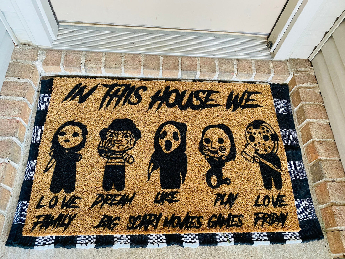 In This House We Love Family Dream Big Like Scary Movies Play Games Love Friday Door Mat in Black